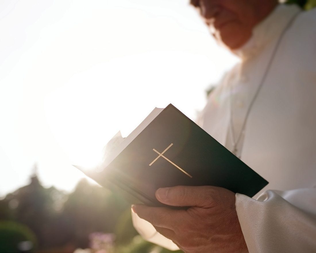 A chaplain holding a book of scripture